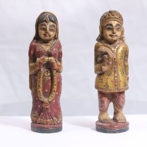 A beautifully hand-carved pair of traditional Indian bride and groom figures, crafted from single wood and enhanced with fine gold-painted detailing.